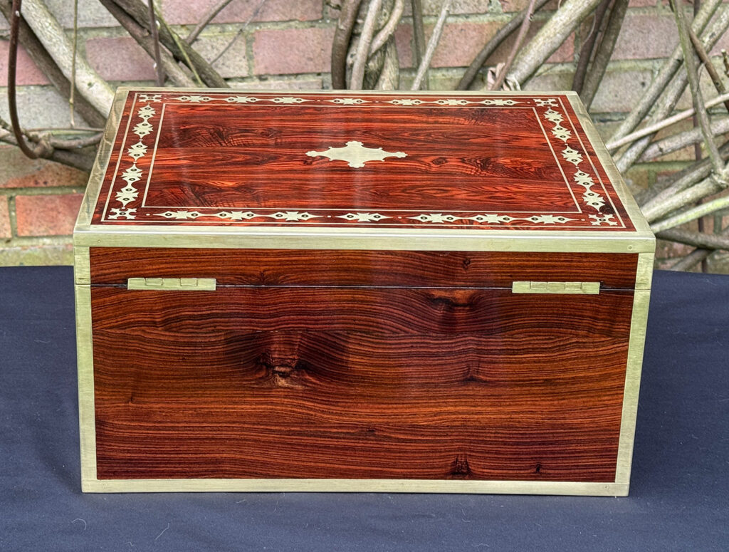 Rear view of an antique jewellery box in kingwood with decorative brass inlay.