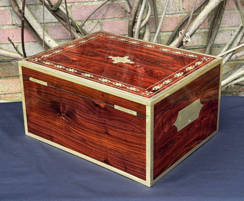 Rear left view of an antique jewellery box in kingwood with decorative brass inlay.