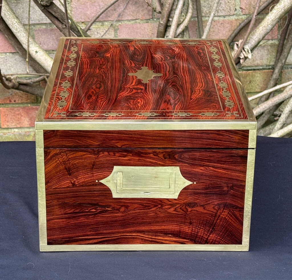 Left side view of an antique jewellery box in kingwood with decorative brass inlay.