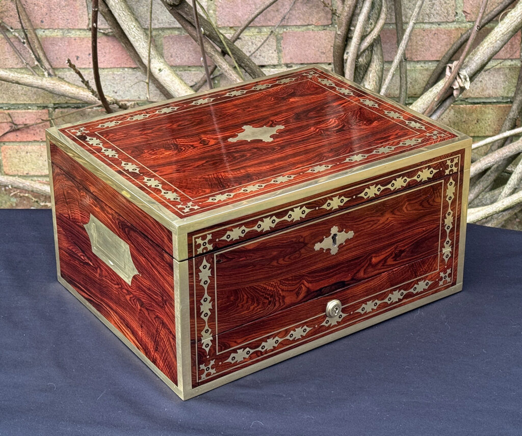 Front left view of an antique jewellery box in kingwood with decorative brass inlay.