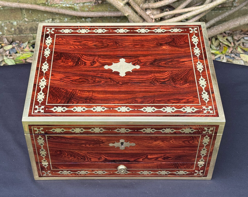 Overhead view of an antique jewellery box in kingwood with decorative brass inlay.