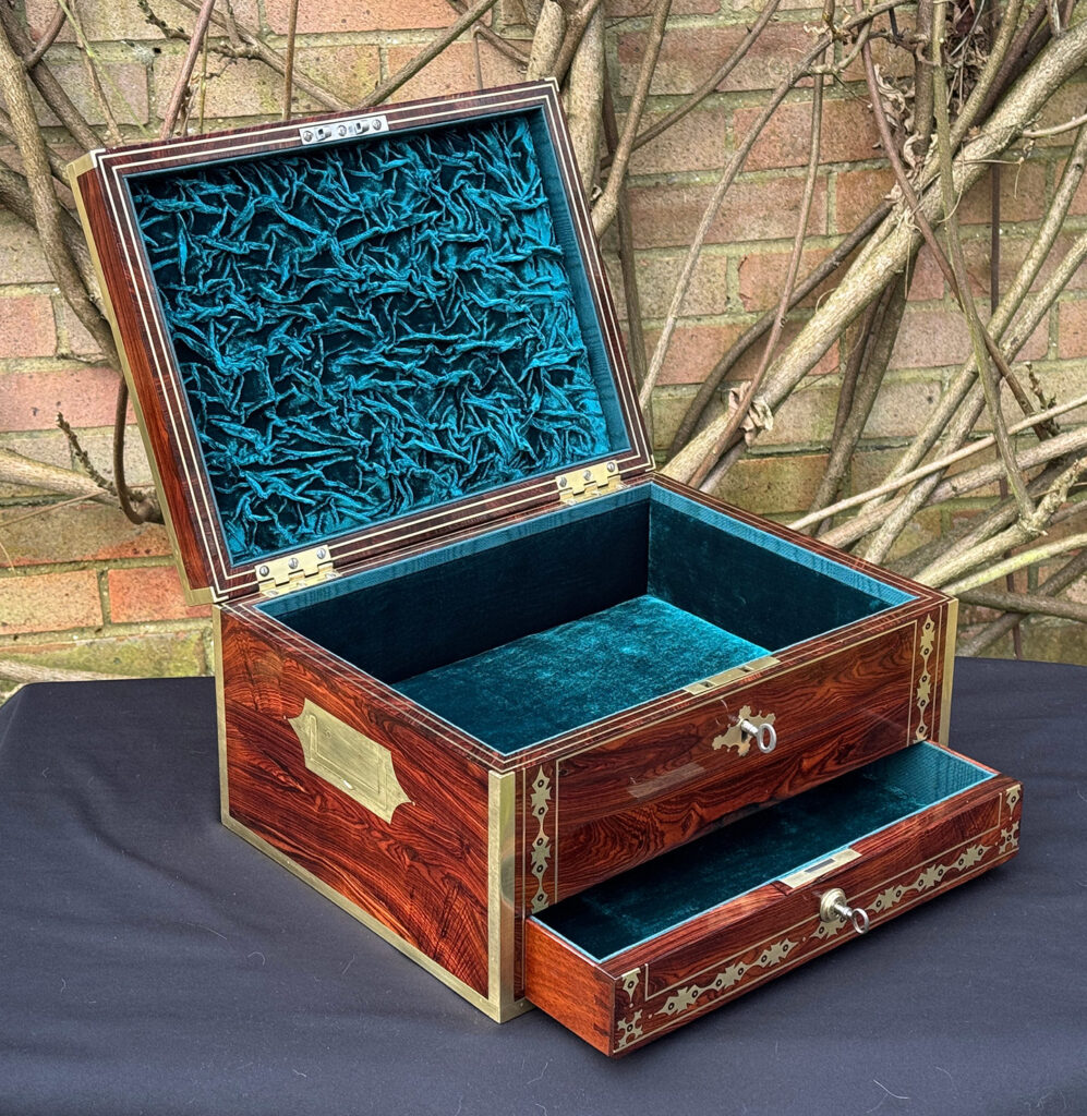 Front left internal view of an antique jewellery box in kingwood with decorative brass inlay with lower drawer opened.