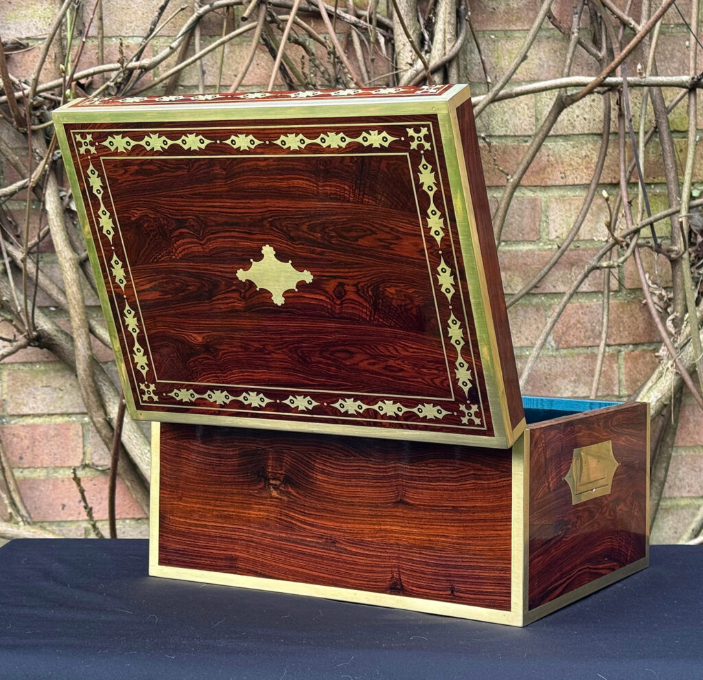 Rear opened view of an antique jewellery box in kingwood with decorative brass inlay.