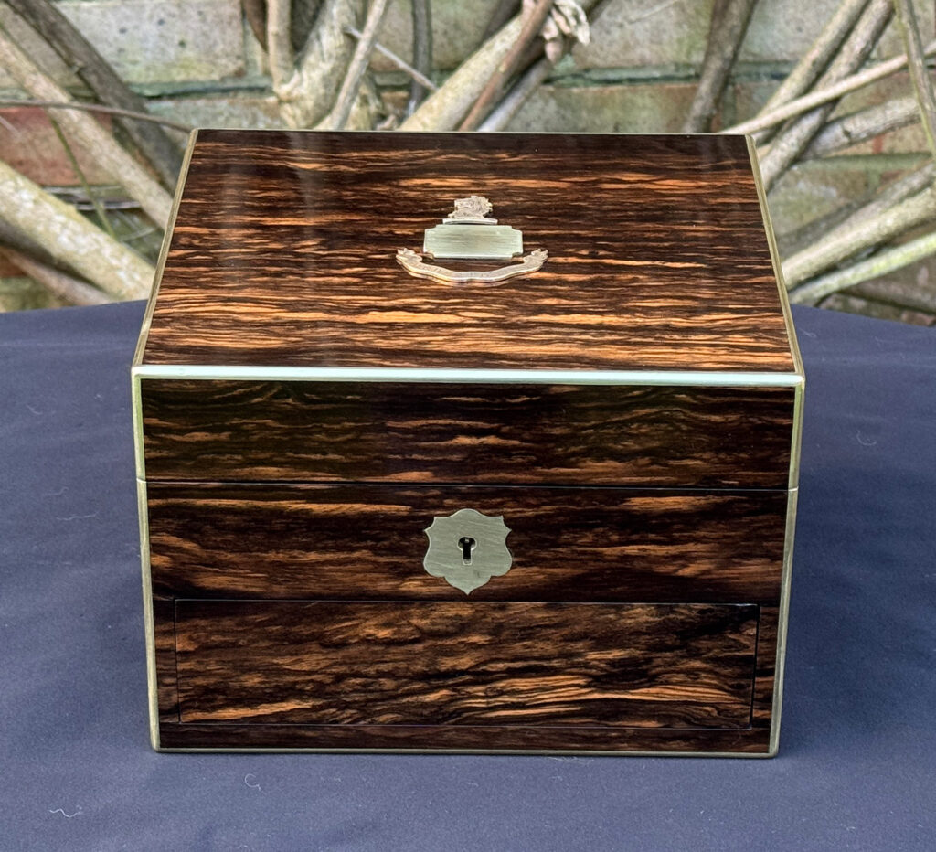 Front view of a miniature antique jewellery box in coromandel, by George Betjemann & Sons.