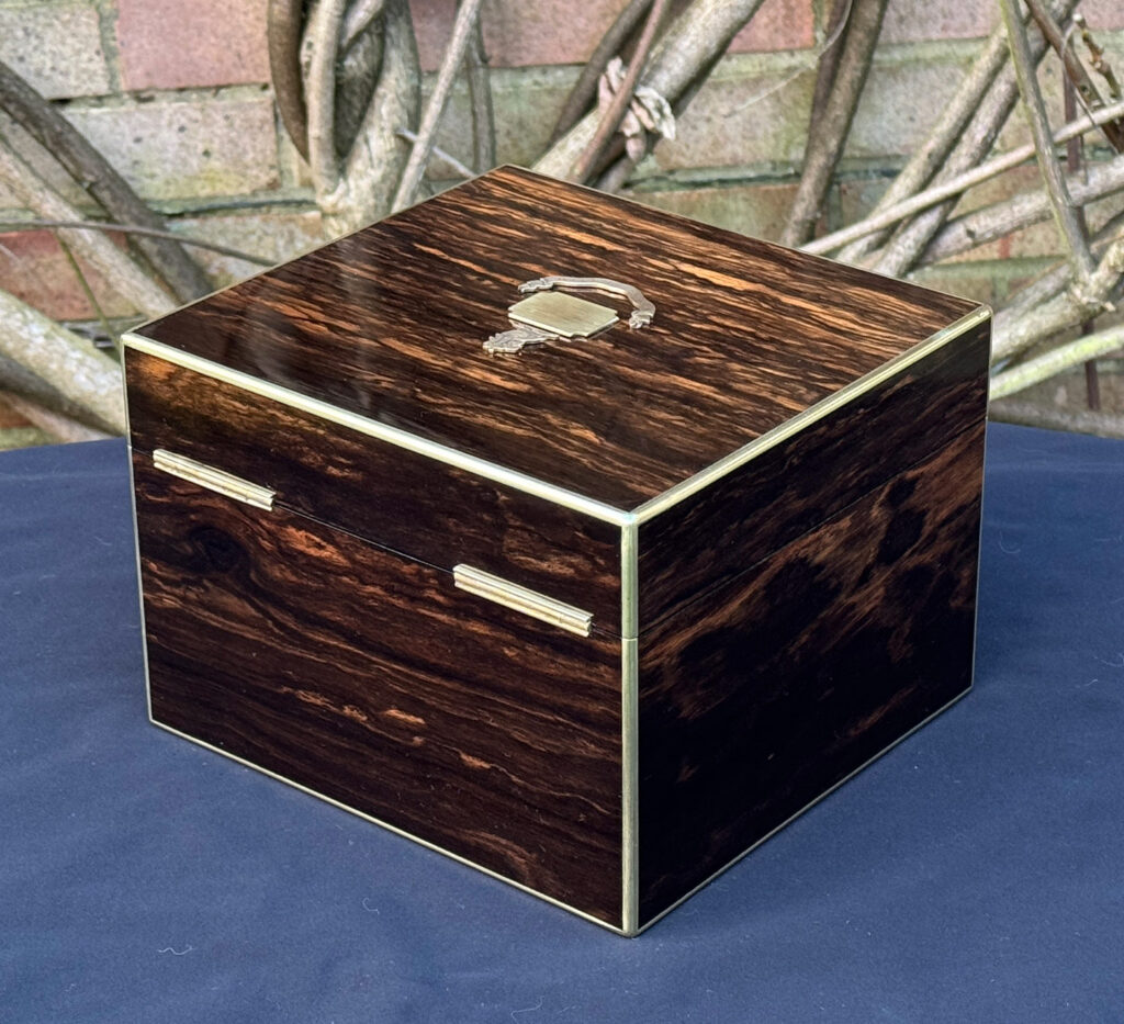 Rear left view of a miniature antique jewellery box in coromandel, by George Betjemann & Sons.