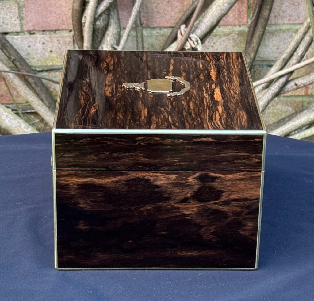 Left side view of a miniature antique jewellery box in coromandel, by George Betjemann & Sons.