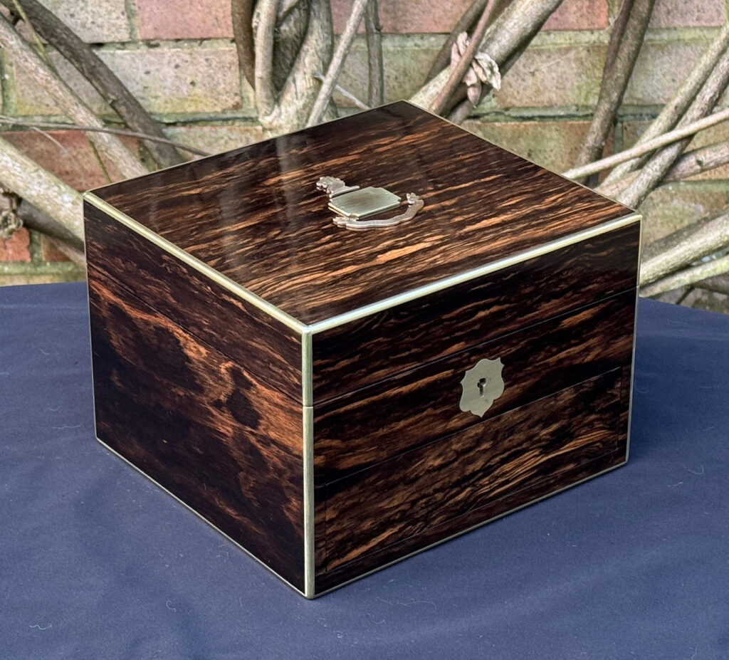 Front left view of a miniature antique jewellery box in coromandel, by George Betjemann & Sons.