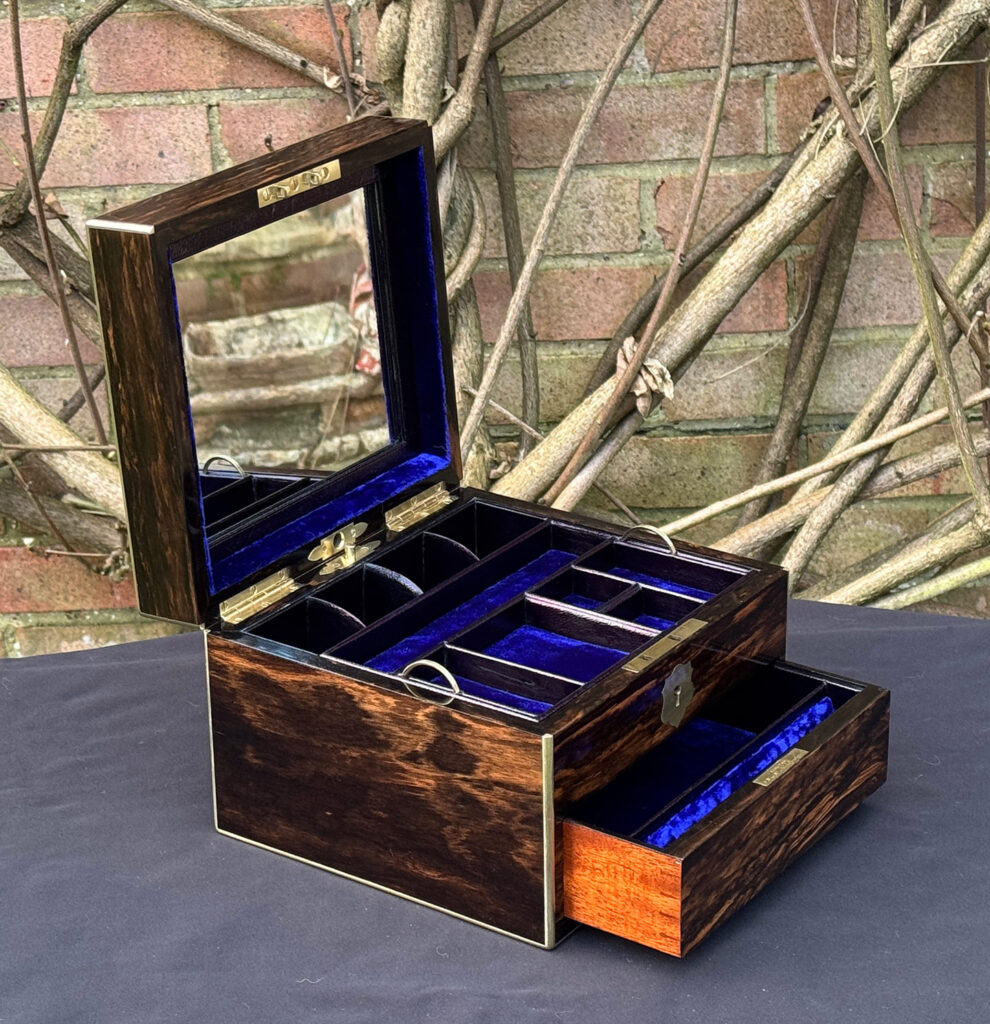 Front left internal view of a miniature antique jewellery box in coromandel, by George Betjemann & Sons, with mirror on display.