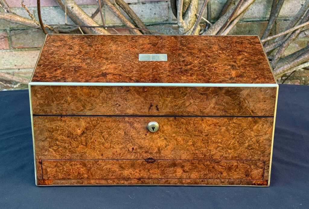Front view of a large antique jewellery box in burr walnut.