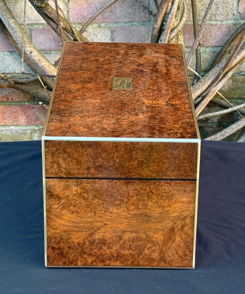 Left side view of a large antique jewellery box in burr walnut.