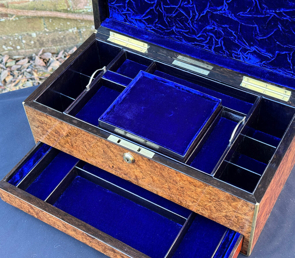 Close internal view of a large antique jewellery box in burr walnut.