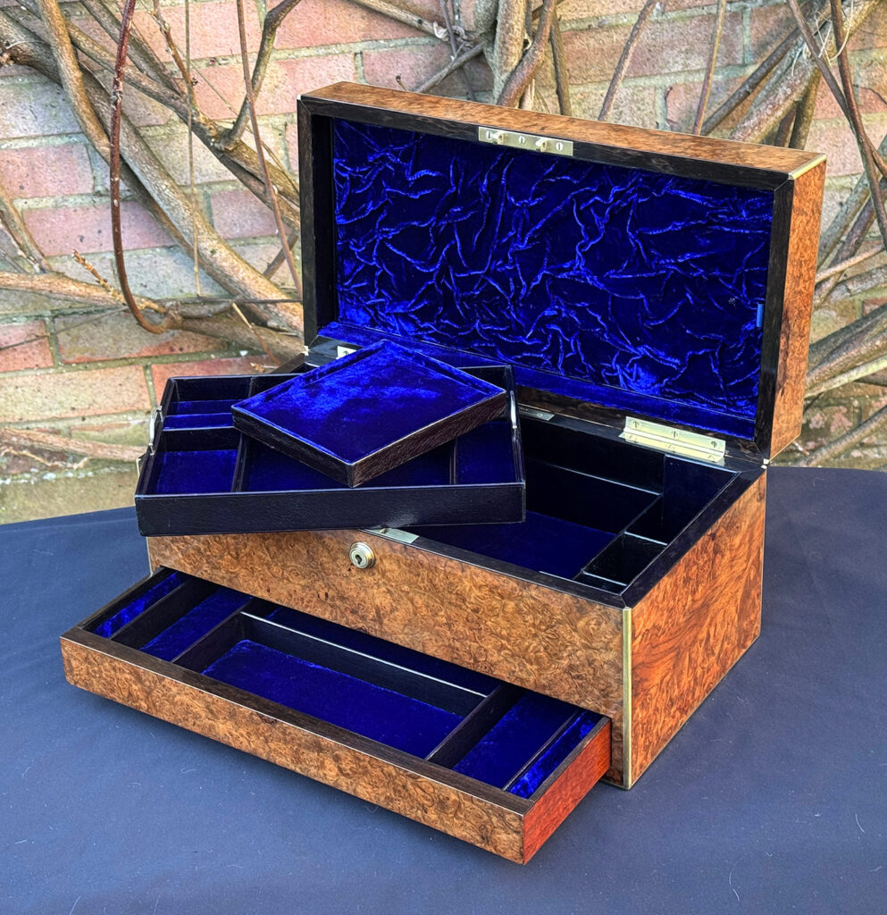 Internal view of a large antique jewellery box in burr walnut, with trays removed.