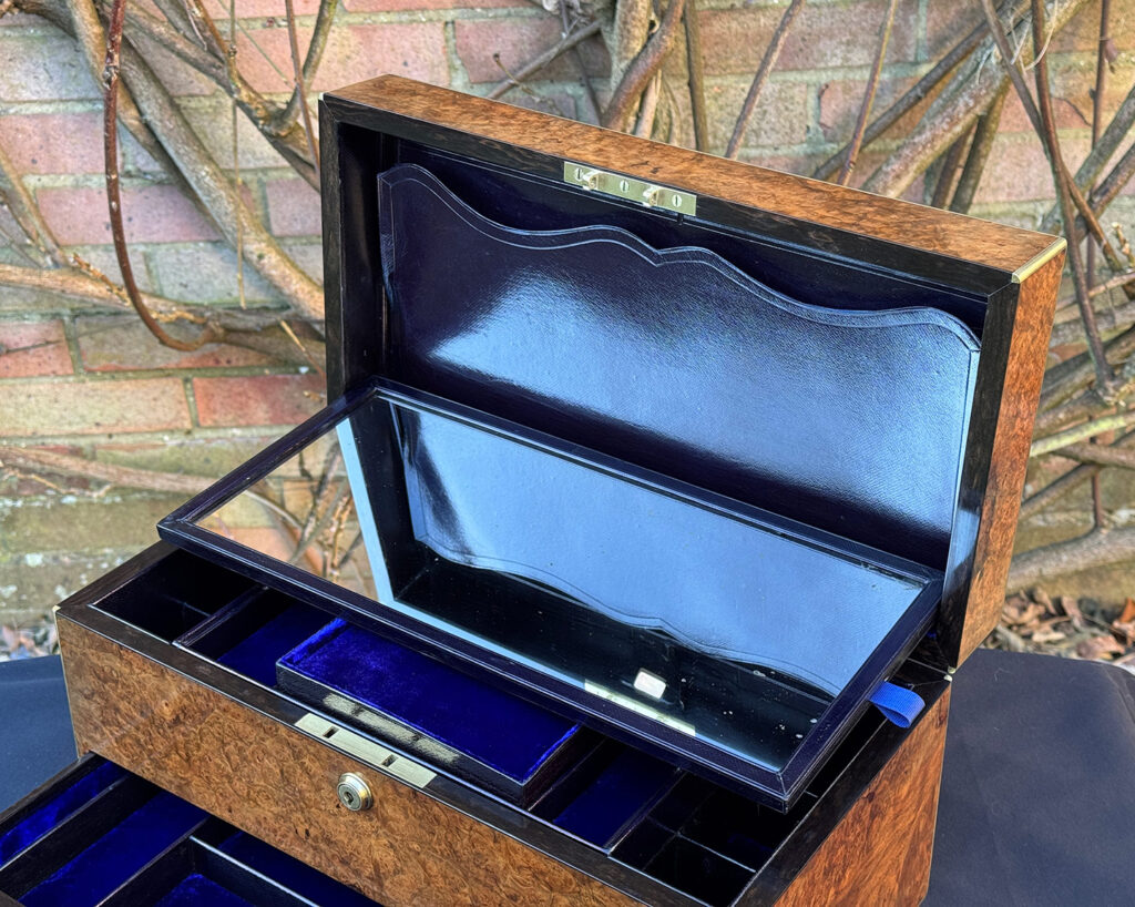 View of a large antique jewellery box in burr walnut with the mirror removed, revealing the letter wallet behind.