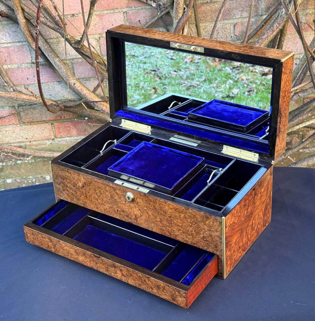 Front right internal view of a large antique jewellery box in burr walnut with mirror on display.
