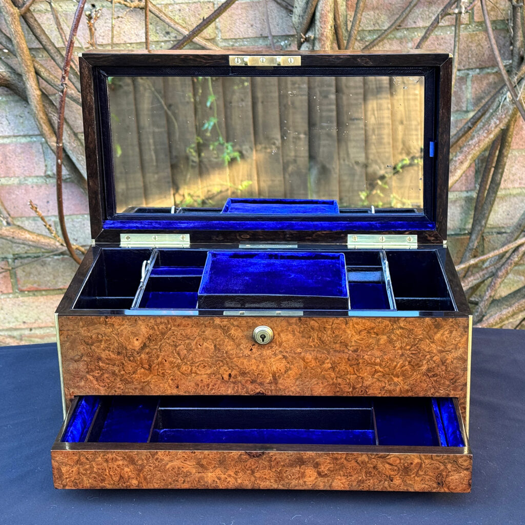Front internal view of a large antique jewellery box in burr walnut with mirror on display.