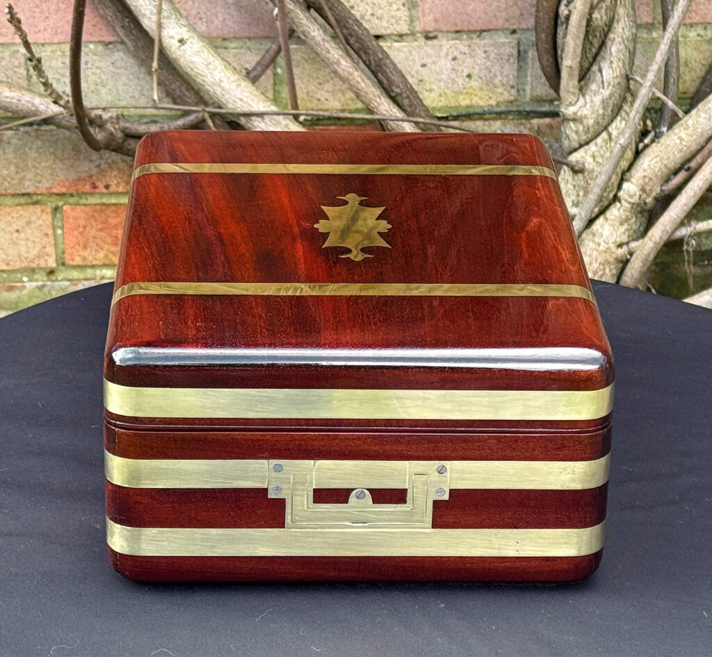 Left side interior view of an antique radial edged travelling jewellery box in mahogany.