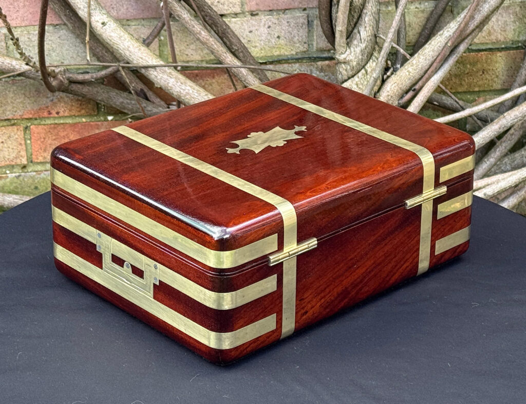 Rear right view of an antique radial edged travelling jewellery box in mahogany.