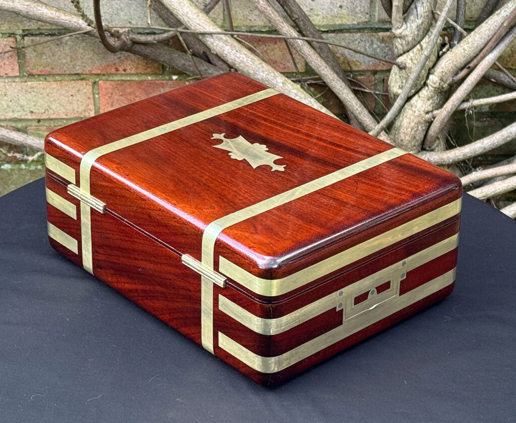 Rear left view of an antique radial edged travelling jewellery box in mahogany.