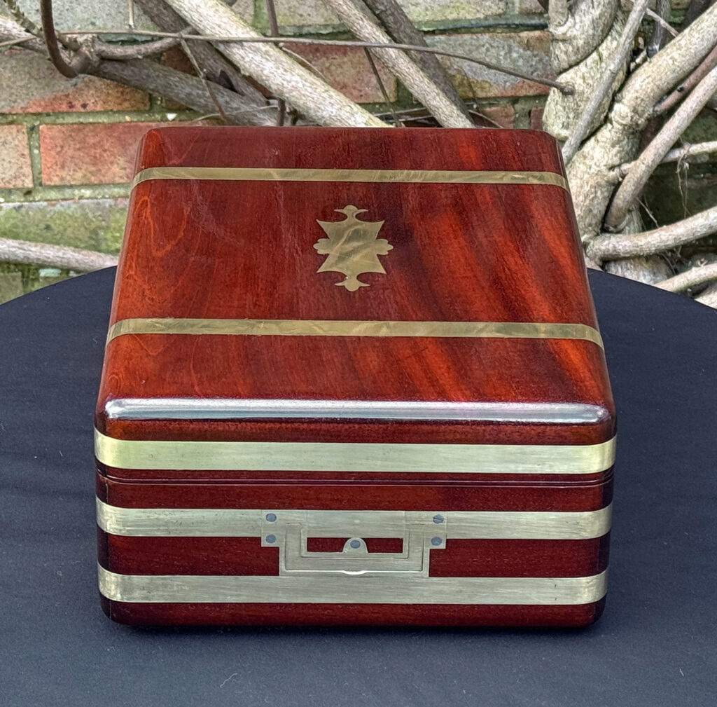 Right side view of an antique radial edged travelling jewellery box in mahogany.