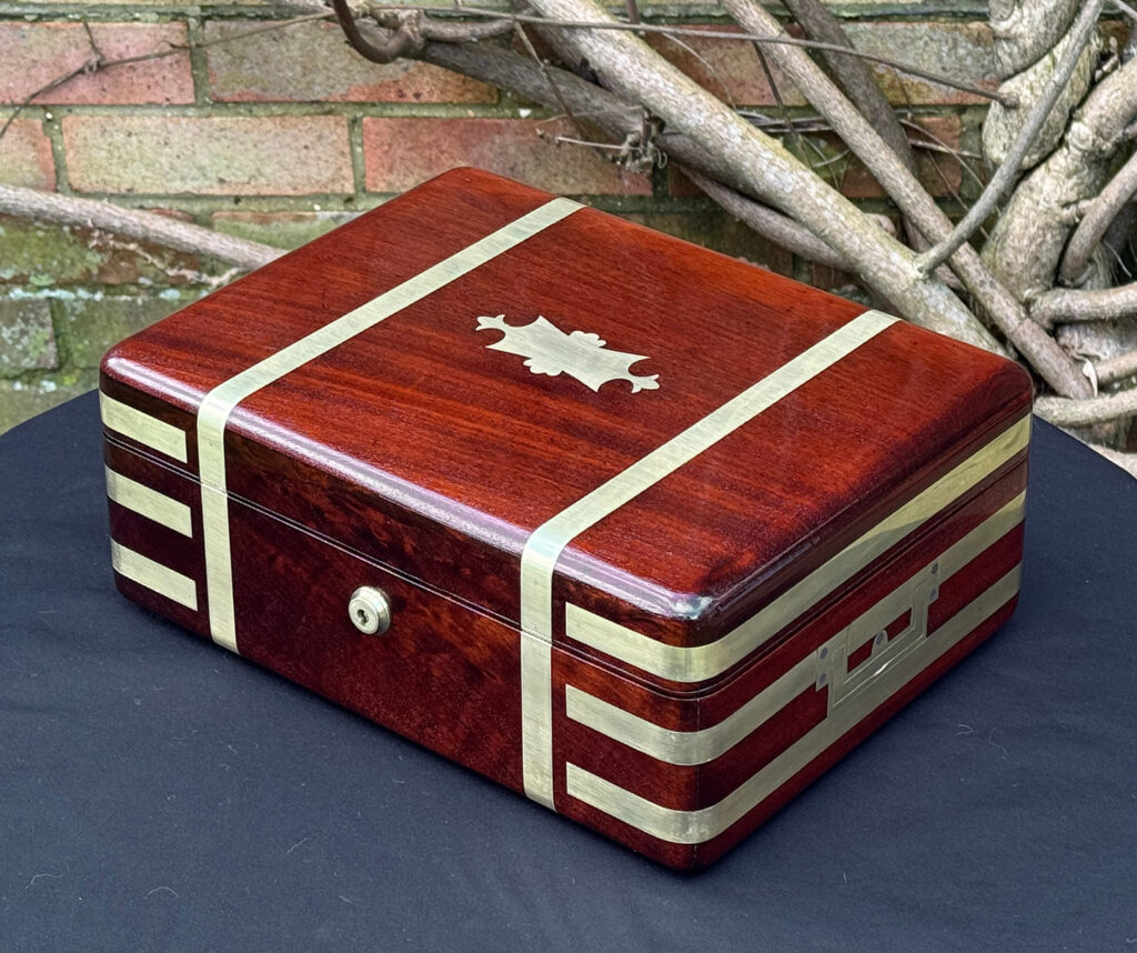 Front right view of an antique radial edged travelling jewellery box in mahogany.
