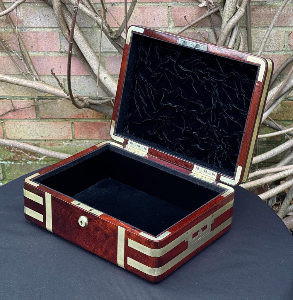 Front right interior view of an antique radial edged travelling jewellery box in mahogany.