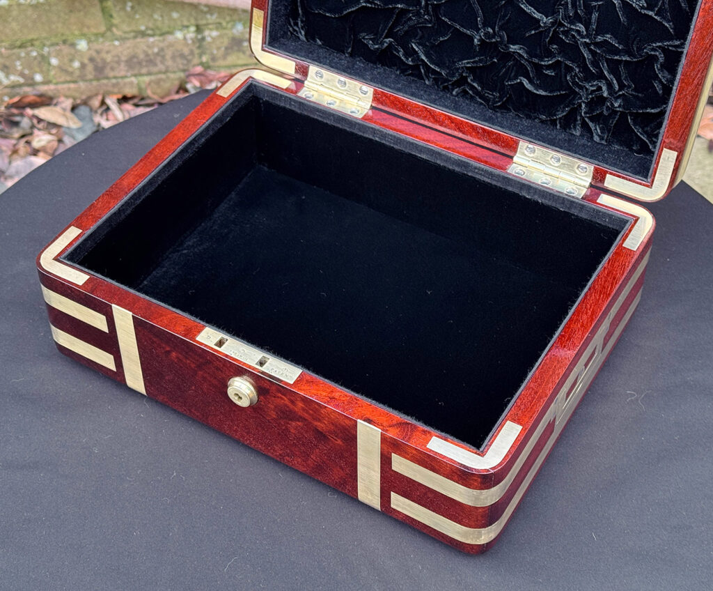 Close interior view of an antique radial edged travelling jewellery box in mahogany.