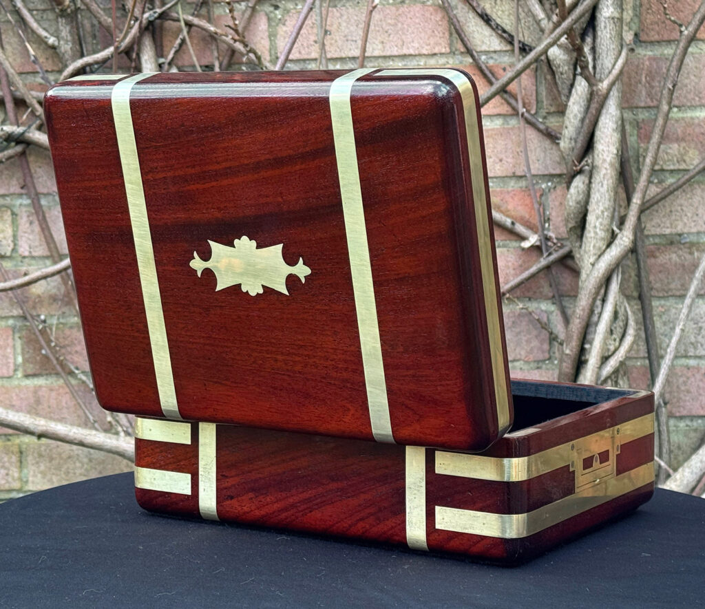 Rear opened view of an antique radial edged travelling jewellery box in mahogany.