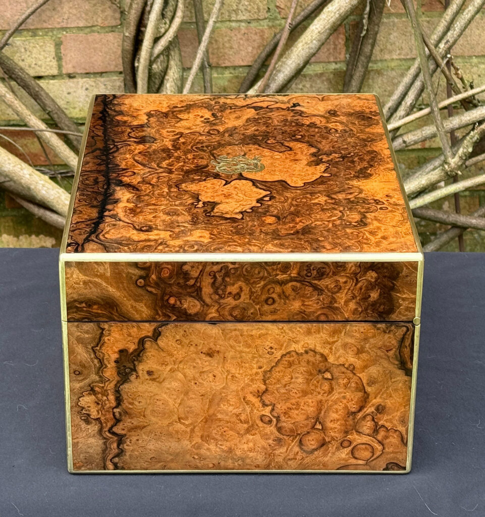Right side view of an antique jewellery box in burr walnut by Halstaff & Hannaford.