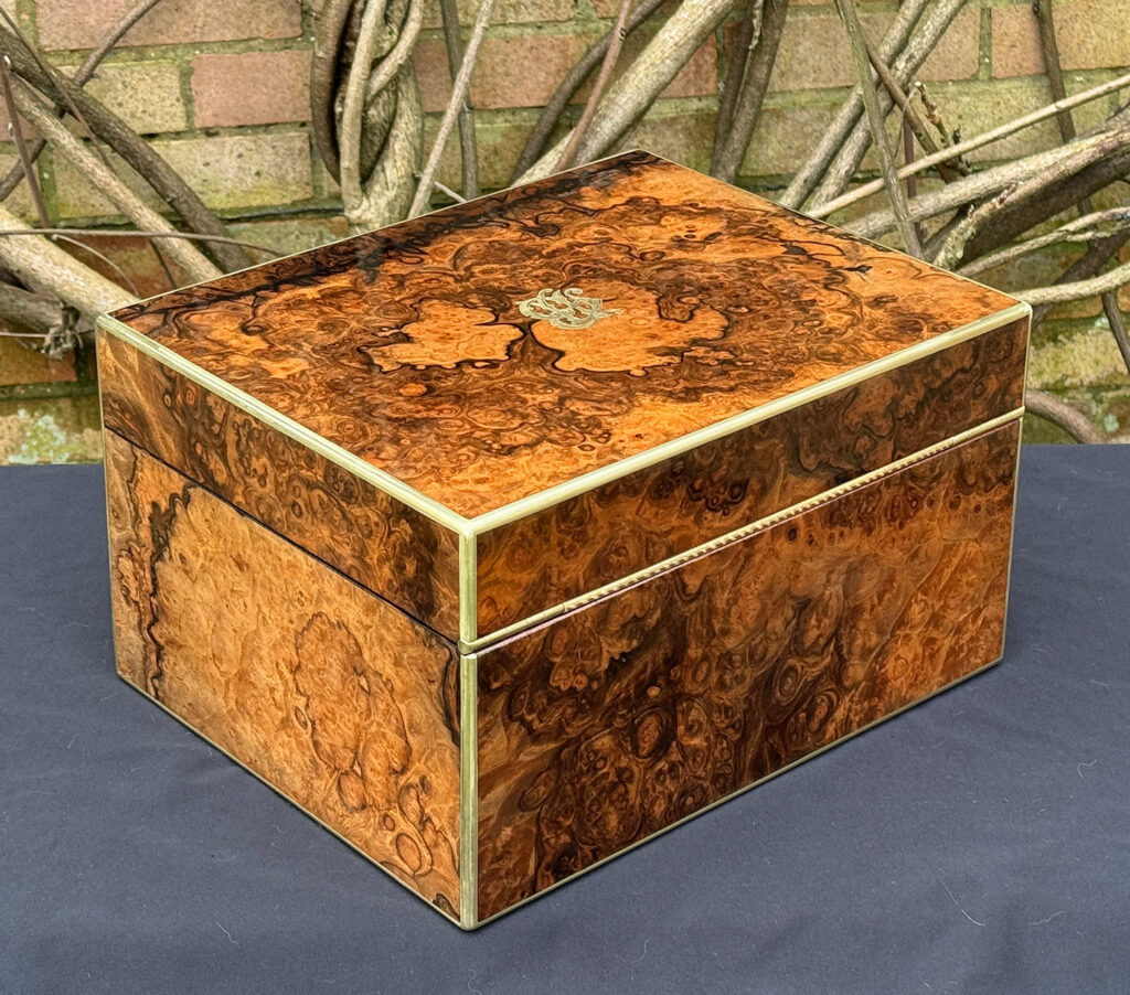 Rear right view of an antique jewellery box in burr walnut by Halstaff & Hannaford.