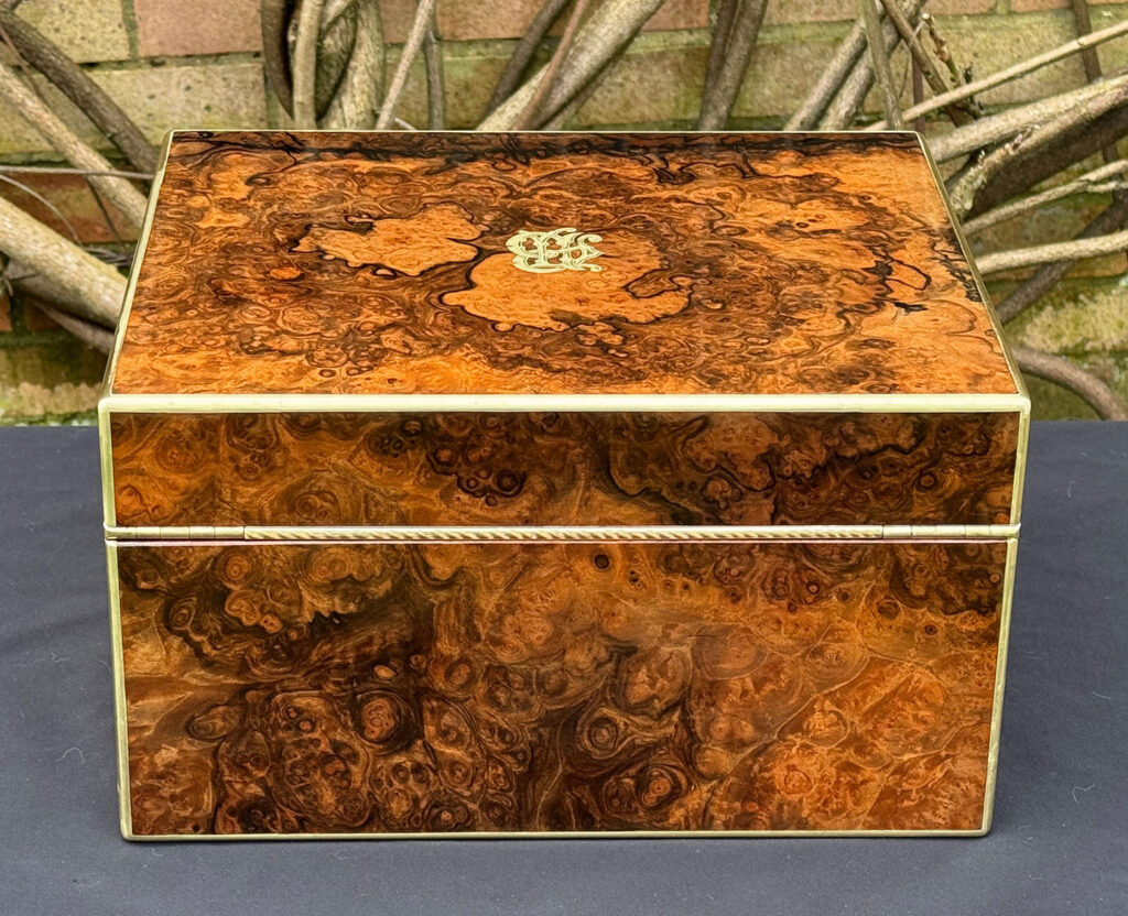 Rear view of an antique jewellery box in burr walnut by Halstaff & Hannaford.