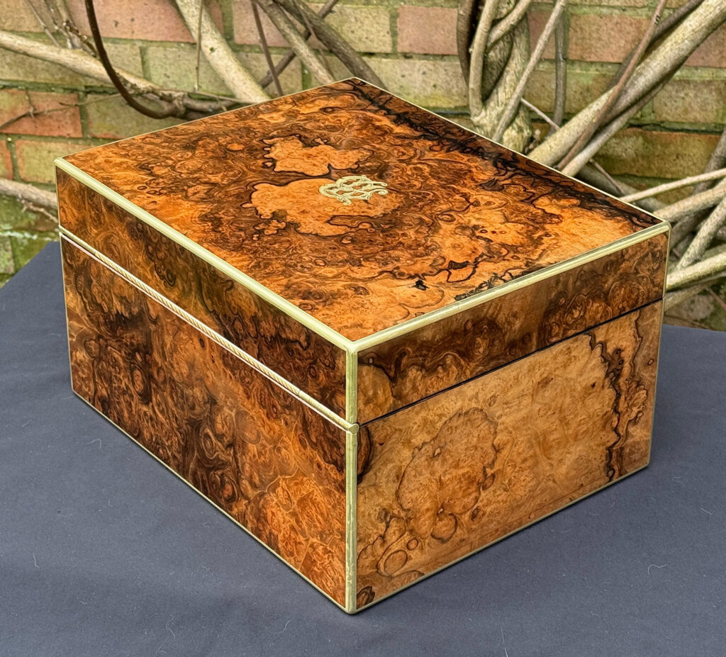 Rear left view of an antique jewellery box in burr walnut by Halstaff & Hannaford.