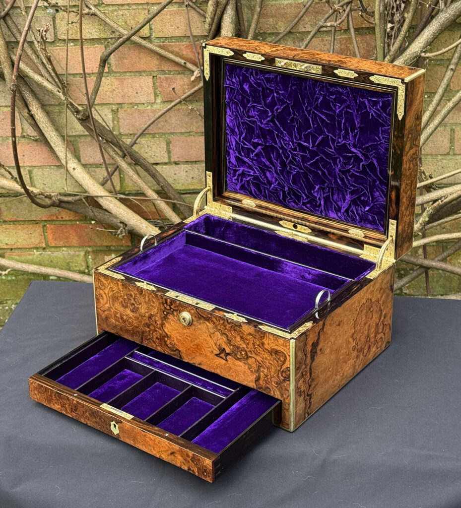Front right interior view of an antique jewellery box in burr walnut by Halstaff & Hannaford, with lower drawer open.