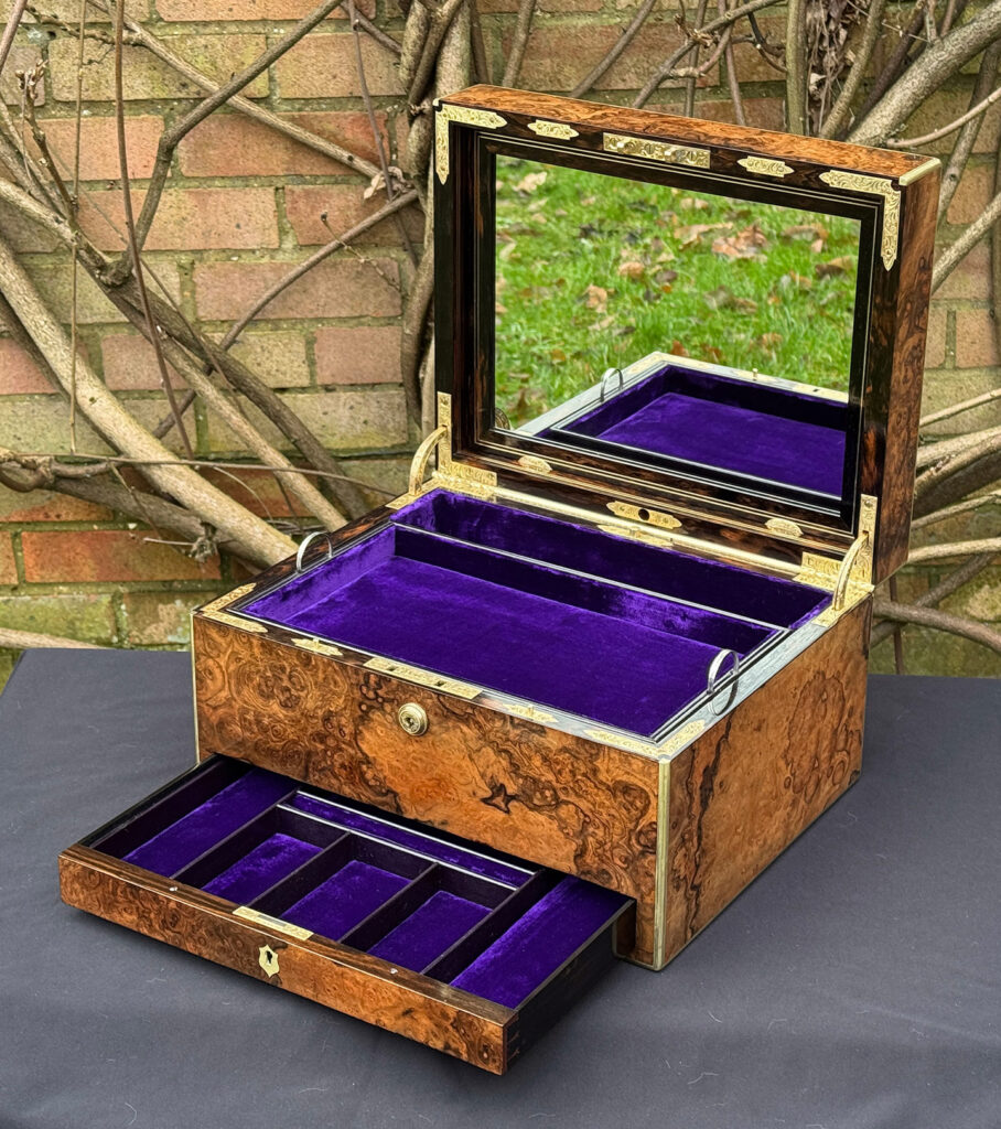 Front right interior view of an antique jewellery box in burr walnut by Halstaff & Hannaford, with mirror on display.