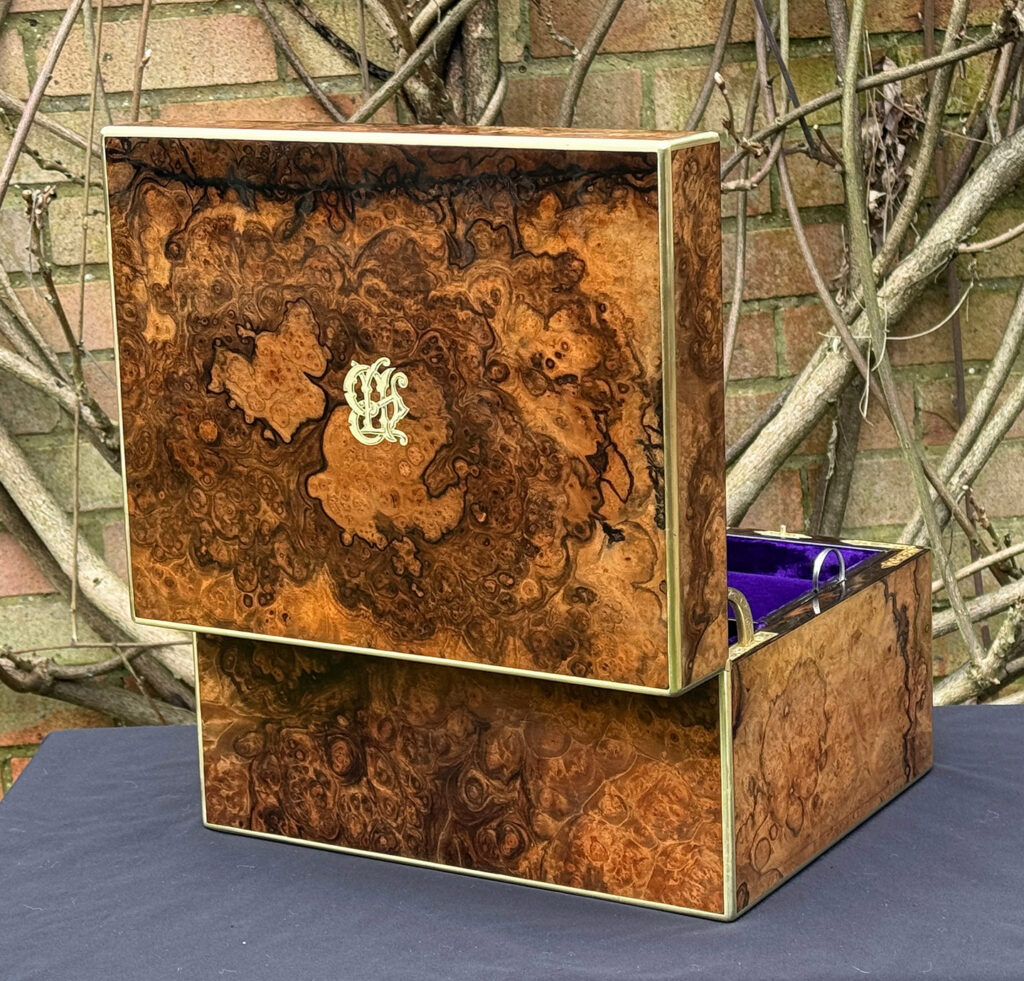Rear opened view of an antique jewellery box in burr walnut by Halstaff & Hannaford.
