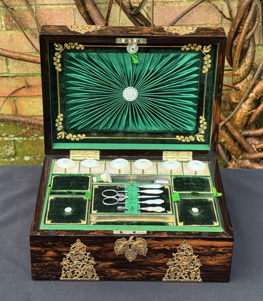 Front interior view of an antique sewing box in coromandel with fretwork foliate brass overlay.
