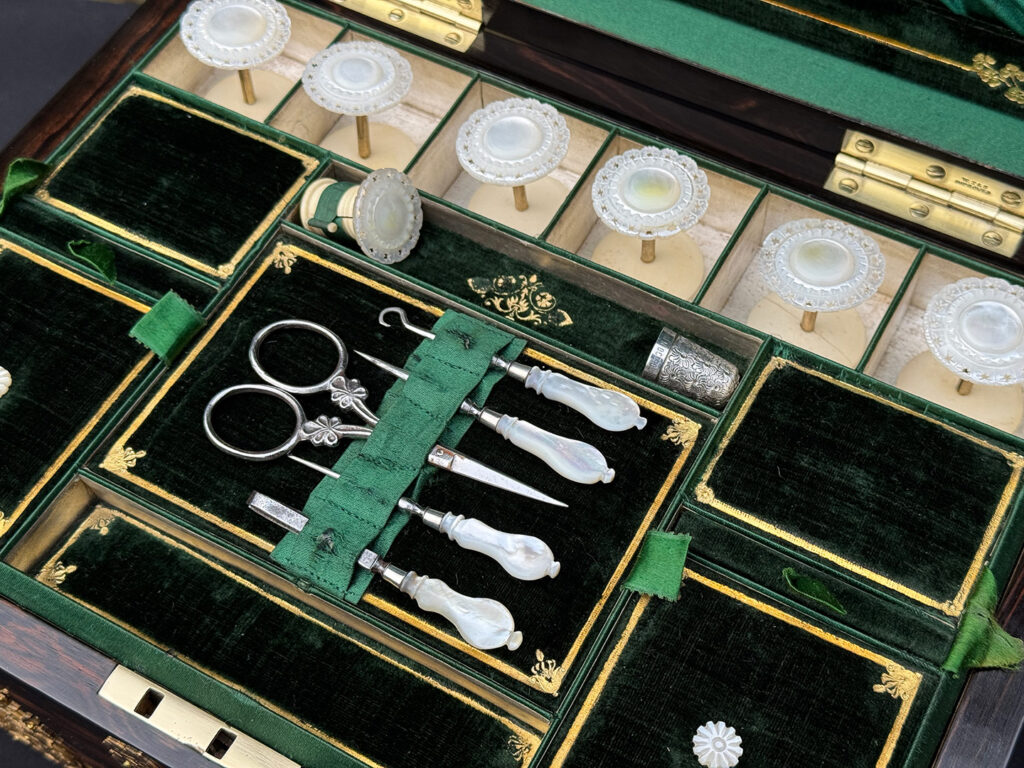 Close up view of the mother of pearl sewing box fittings.