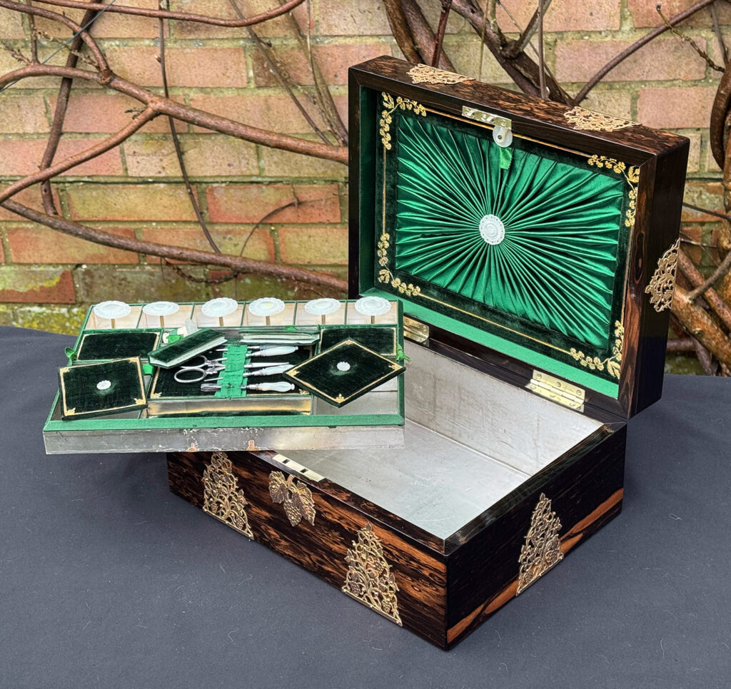 Front right interior view of an antique sewing box in coromandel with fretwork foliate brass overlay.