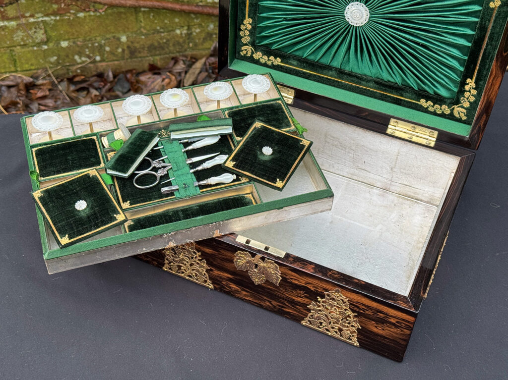 Closer interior view of an antique sewing box in coromandel with fretwork foliate brass overlay.