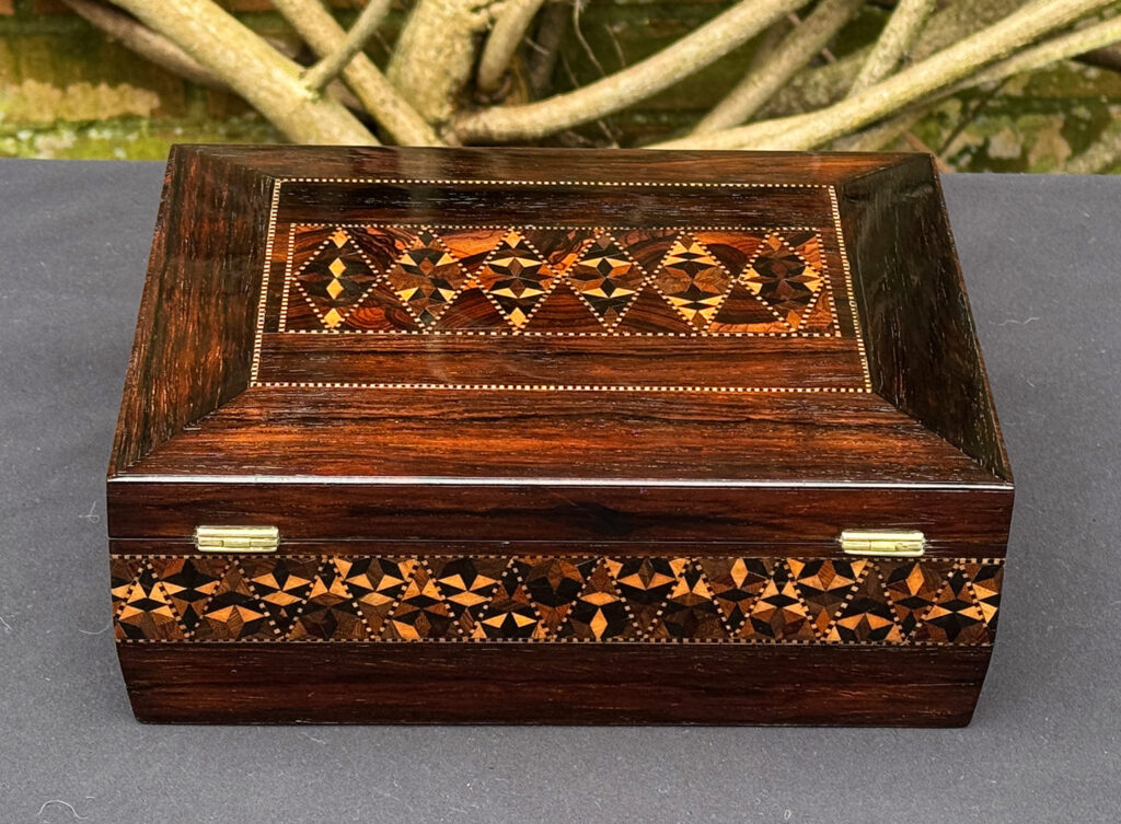 Rear view of a small antique jewellery box in rosewood with parquetry inlay.