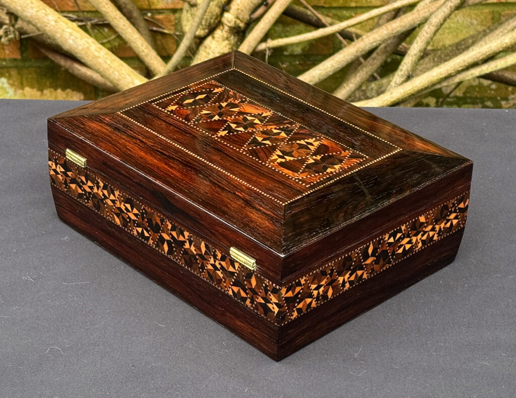 Rear left view of a small antique jewellery box in rosewood with parquetry inlay.