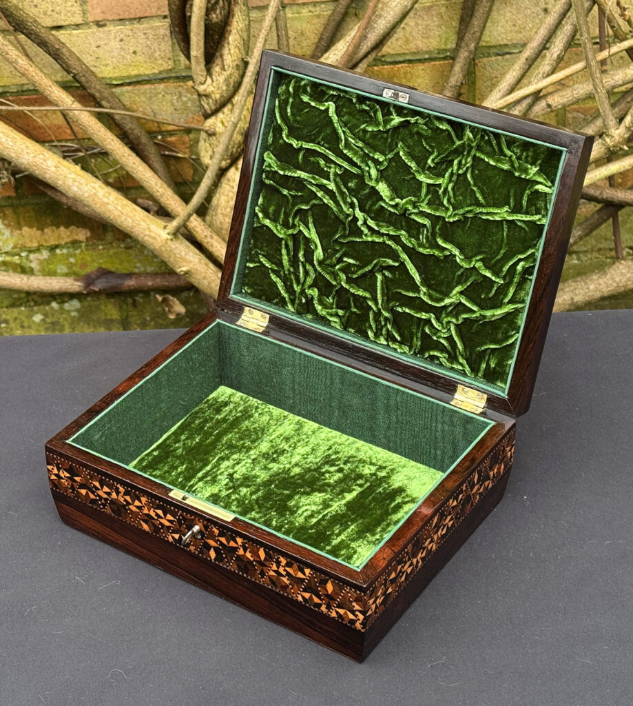 Front right interior view of a small antique jewellery box in rosewood with parquetry inlay.