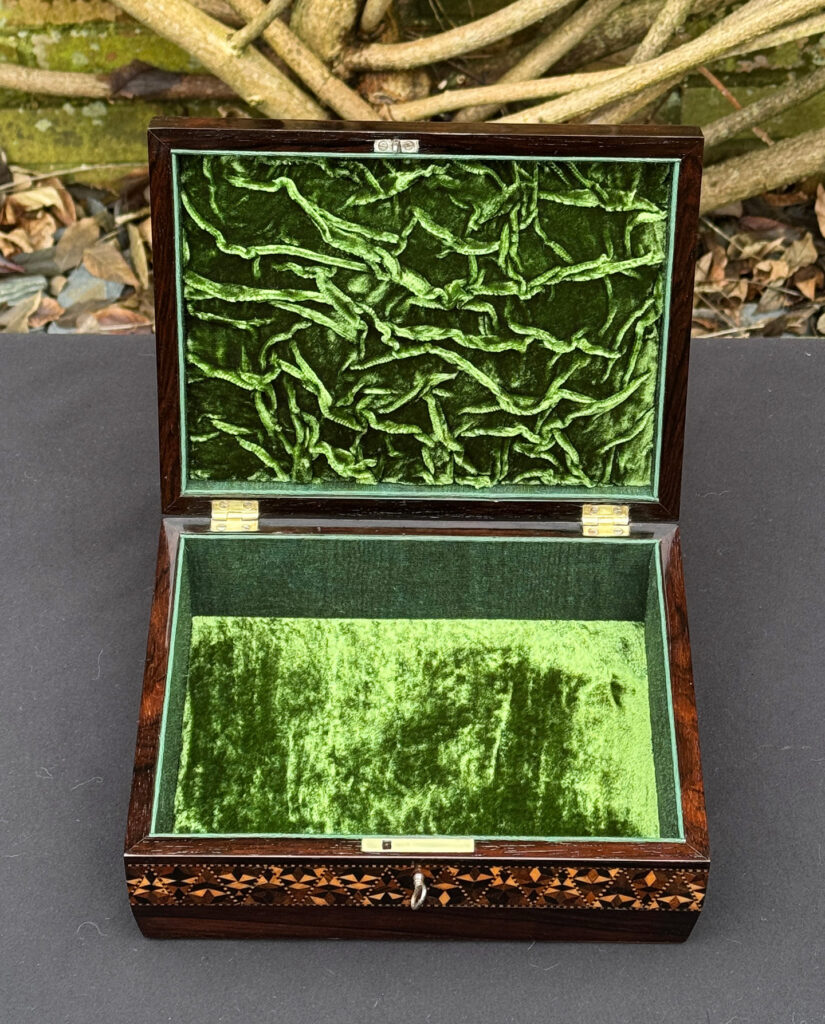 Front interior view of a small antique jewellery box in rosewood with parquetry inlay.