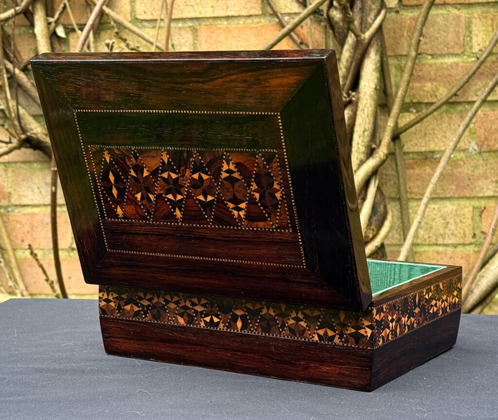 Rear opened view of a small antique jewellery box in rosewood with parquetry inlay.