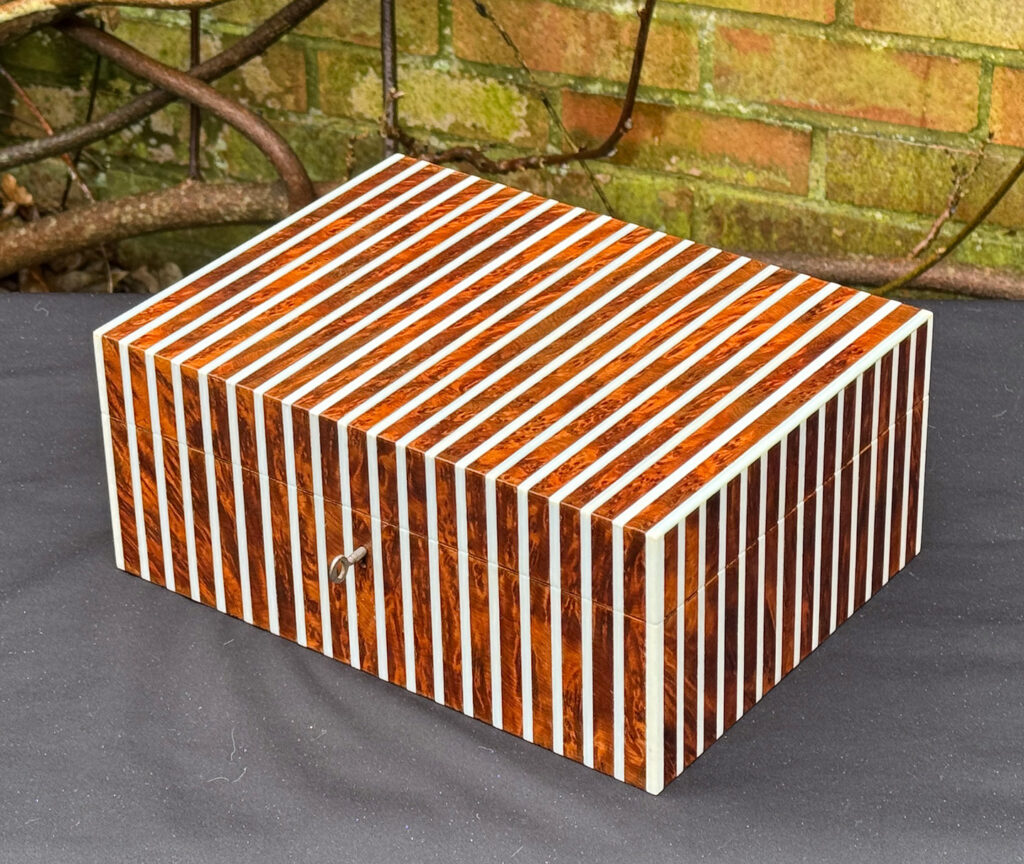 Front right view of an antique Edwardian cigar box in thuya wood with ivory striped inlay.