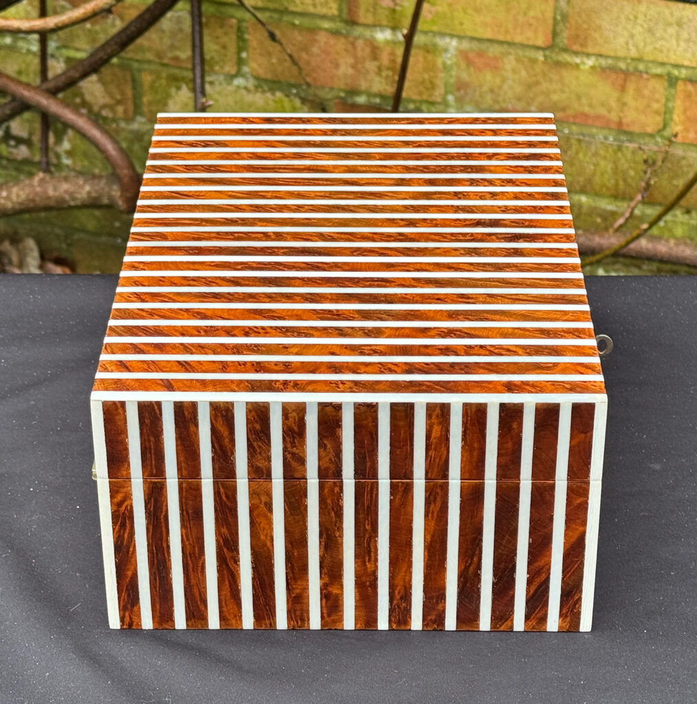 Left side view of an antique Edwardian cigar box in thuya wood with ivory striped inlay.