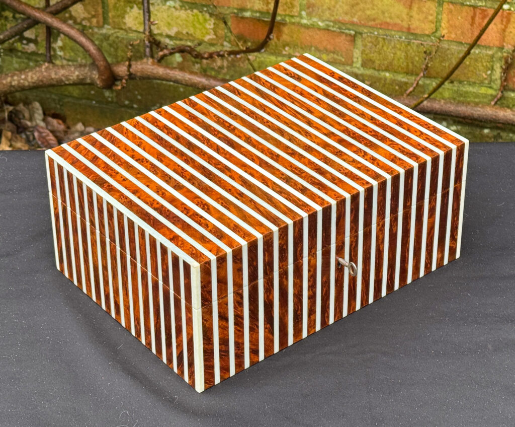 Front left view of an antique Edwardian cigar box in thuya wood with ivory striped inlay.