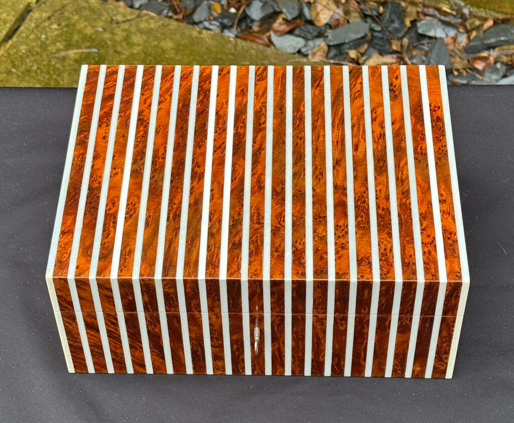Overhead view of an antique Edwardian cigar box in thuya wood with ivory striped inlay.