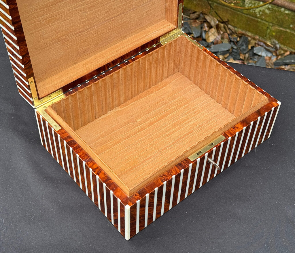 Overhead left interior view of an antique Edwardian cigar box in thuya wood with ivory striped inlay.