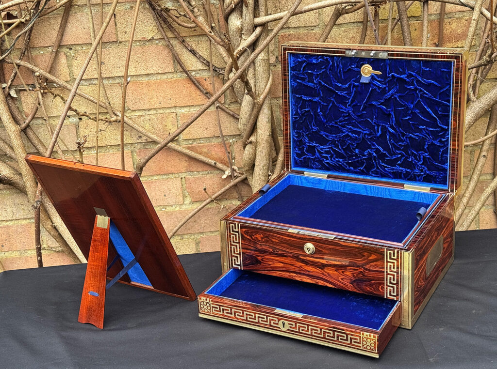 Front right interior view of an antique jewellery box in kingwood, by Wells & Lambe, with the back of the freestanding mirror on display.