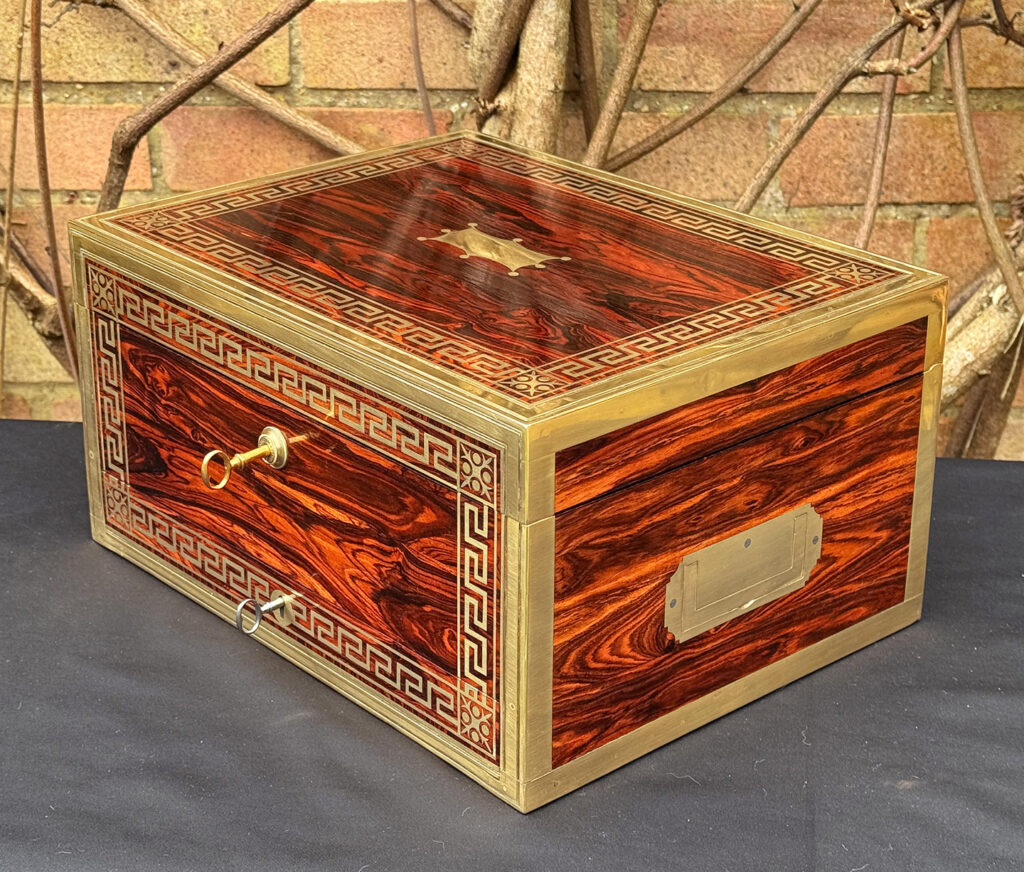 Front right view of an antique jewellery box in kingwood, by Wells & Lambe, with both keys in locks.